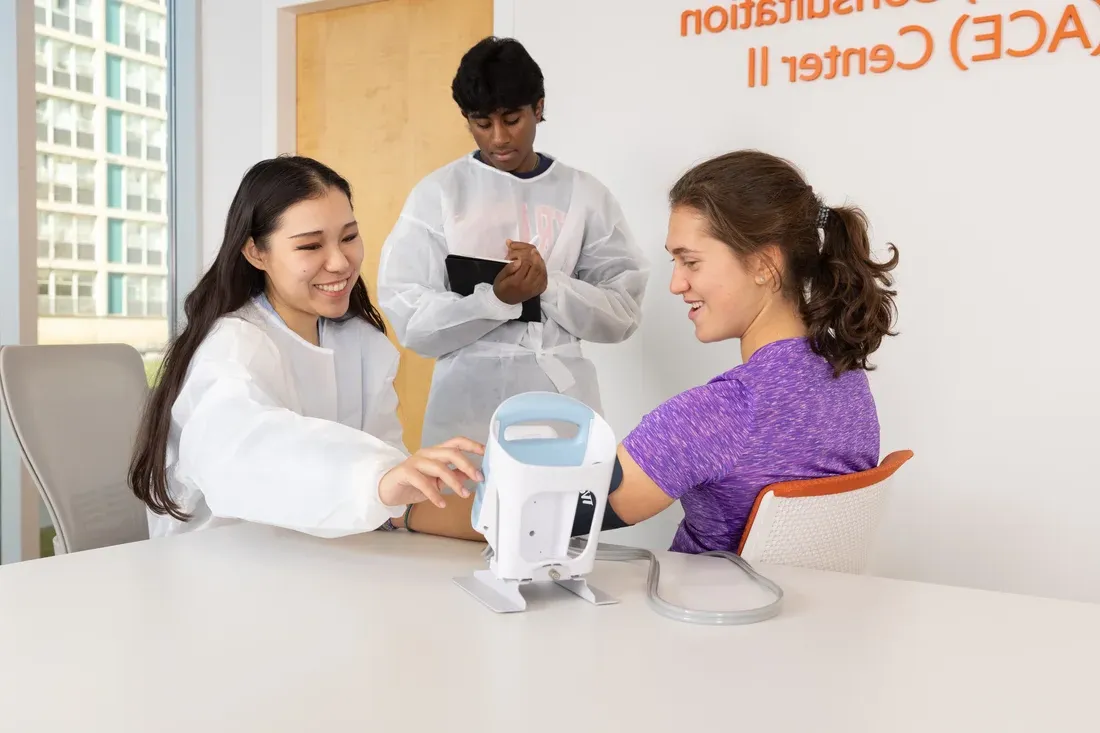 在厄尼·戴维斯实验室，一个学生正在给另一个学生测量血压.